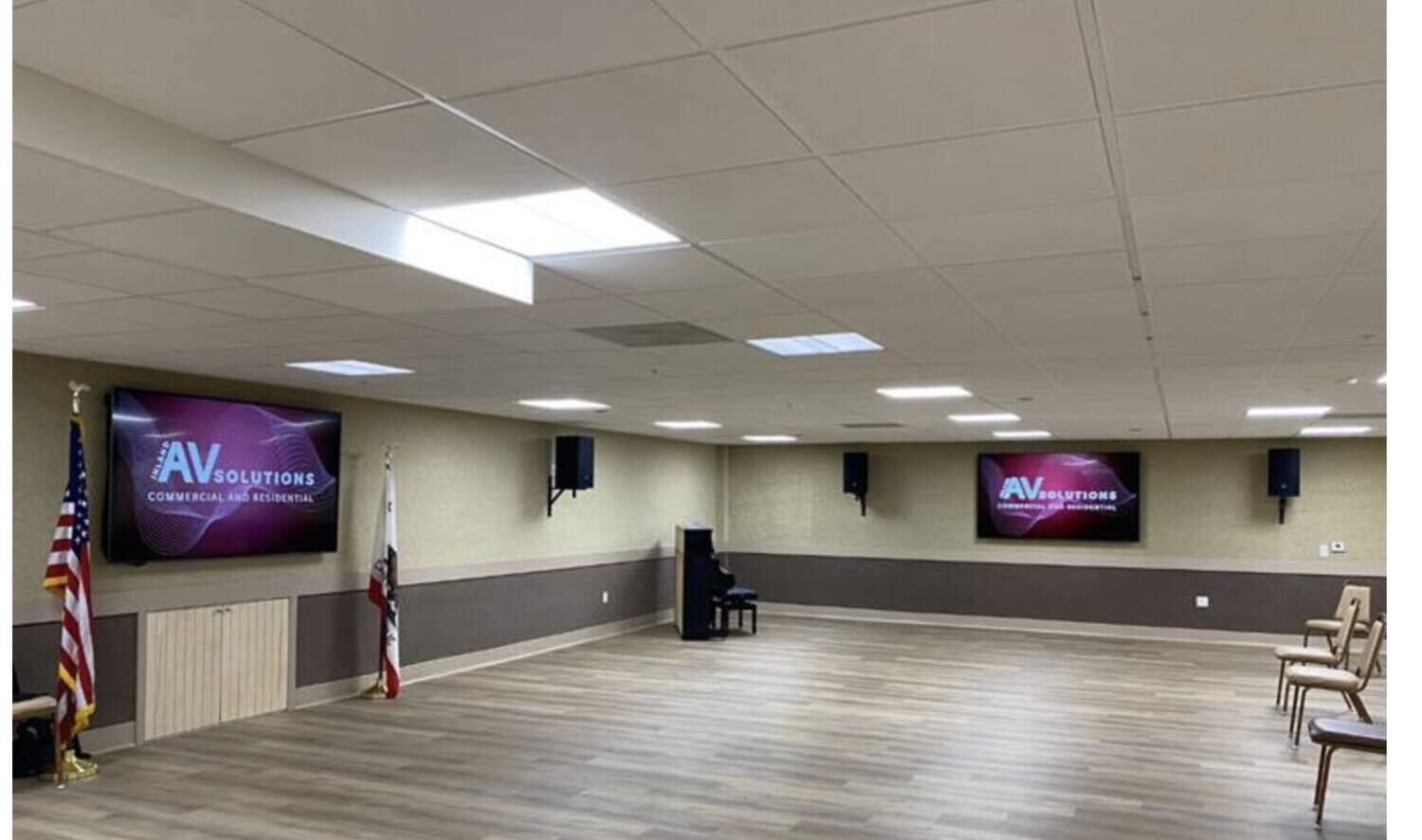 Commercial multipurpose room with wall-mounted displays and distributed audio installed by Inland AV Solutions