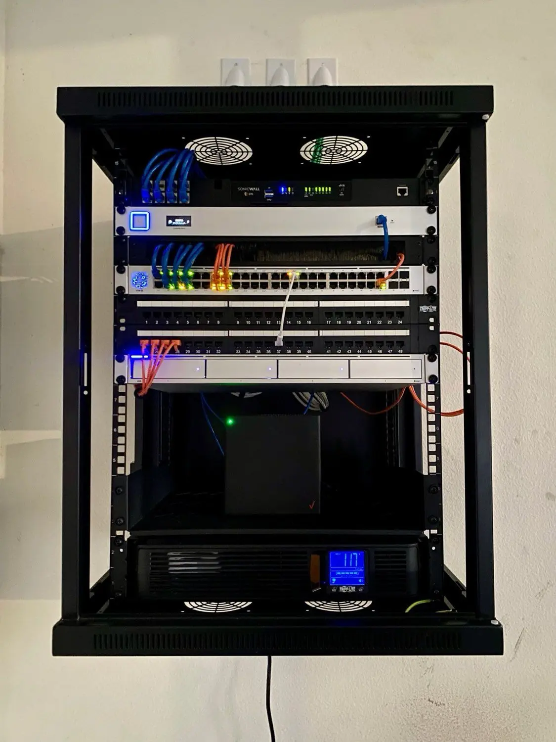 Clean, professionally cabled low-voltage network rack with SonicWall firewall, managed switches, and structured patch panels